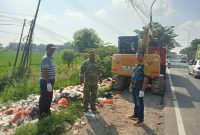 Keterangan Poto: Aparatur Desa Waringinjaya bersama TNI POLRI gotong royong membersihkan sampah