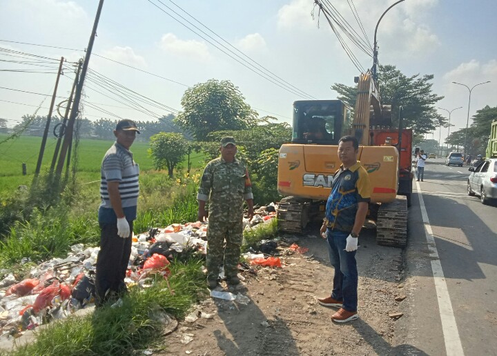 Keterangan Poto: Aparatur Desa Waringinjaya bersama TNI POLRI gotong royong membersihkan sampah