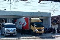 Keterangan gambar kendaraan box kargo tampak menurunkan barang ke bangunan yang diduga kuat akan beroperasi sebagai Alfamart