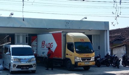 Keterangan gambar kendaraan box kargo tampak menurunkan barang ke bangunan yang diduga kuat akan beroperasi sebagai Alfamart