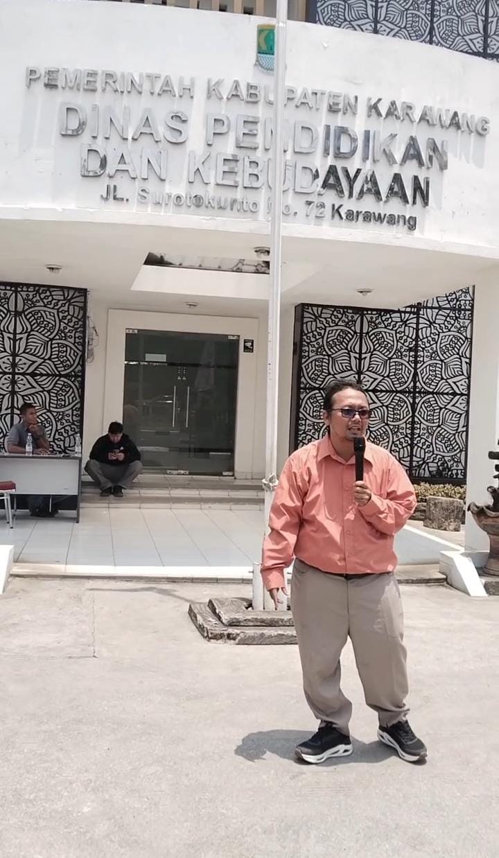 Keterangan photo: Puga Hilal Bayhaqie pegiat media sosial melakukan aksi didepan dinas pendidikan dan kebudayaan karawang